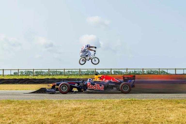 BMX rider jumps moving Red Bull F1